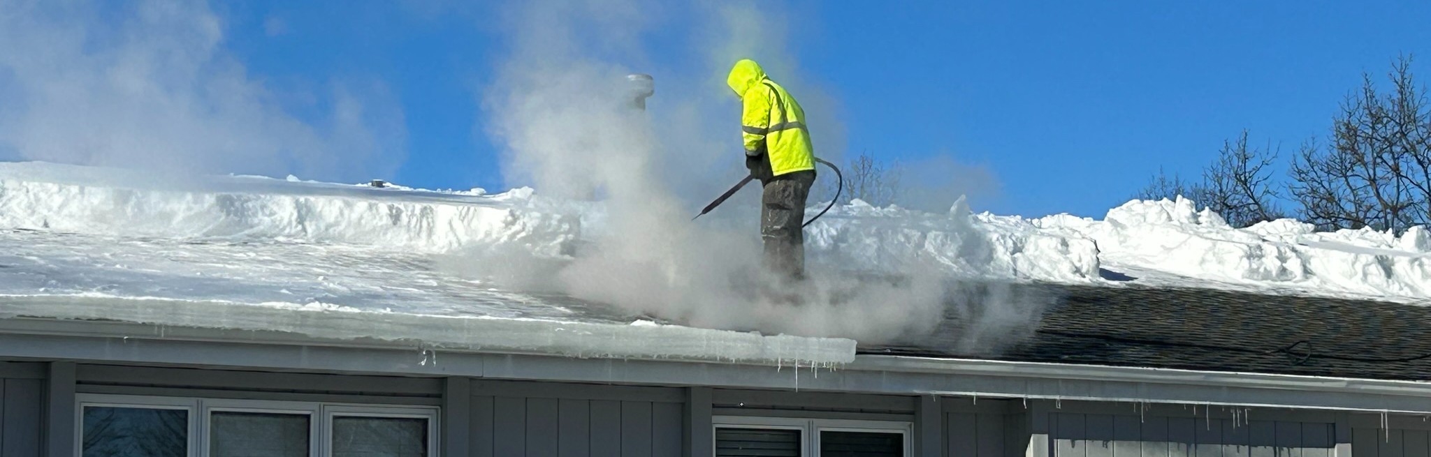 Removing ice dam to stop roof leaking.