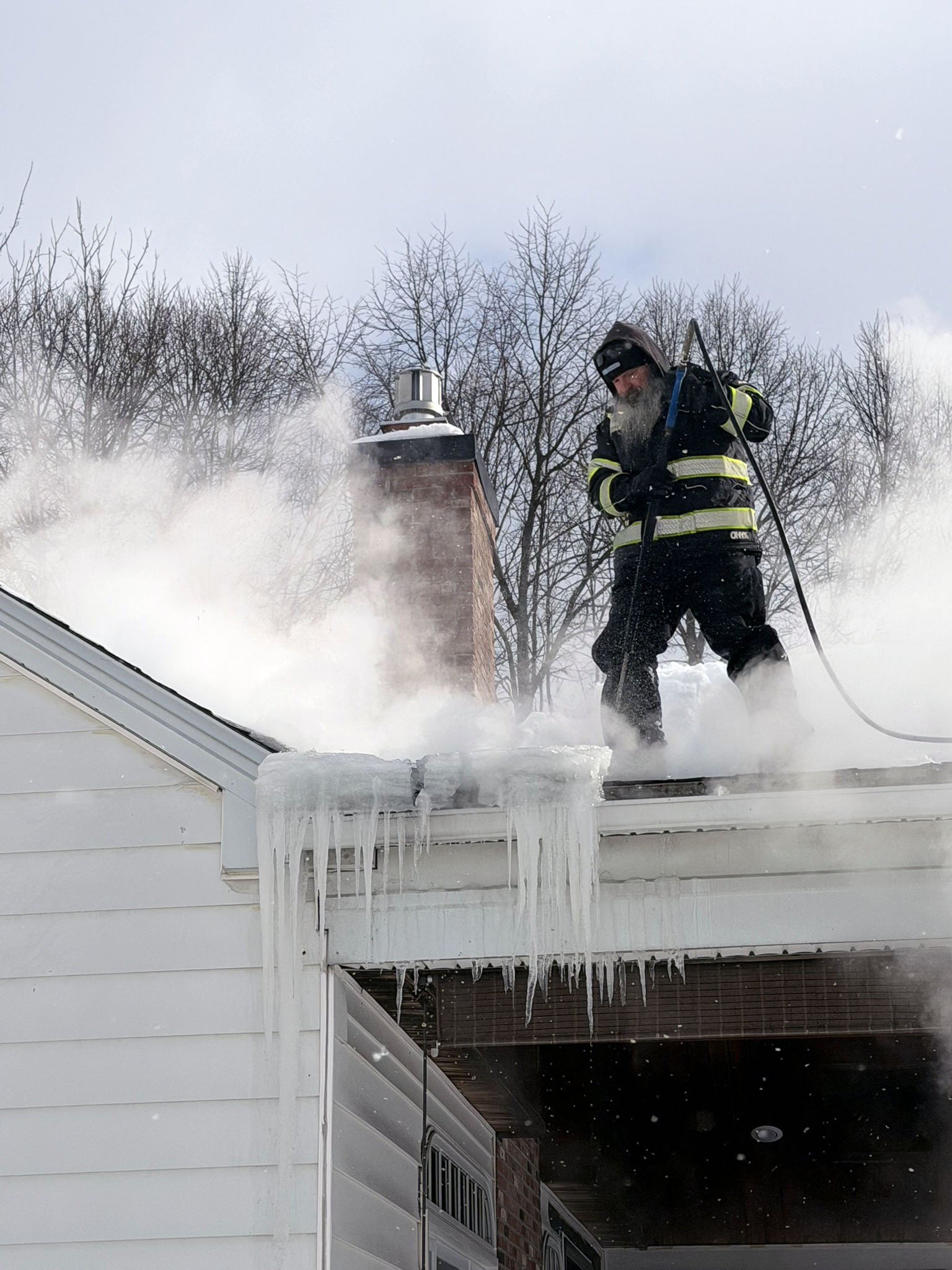 Ice Dam Removal In Lockport NY Steaming ice dam on roof in Lockport NY.